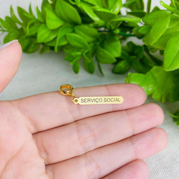 Berloque Plaquinha Serviço Social dourado — detalhe da peça Work Semijoias
